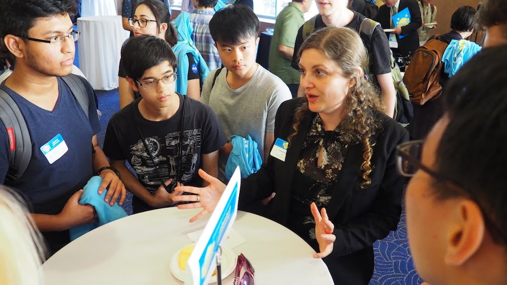 A female UCLA instructor sits around a table of new students talking to them about the division of physical sciences