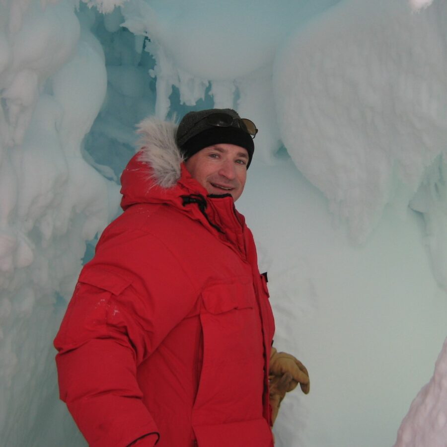 Professor David Saltzberg poses in front of ice in Antarctica.
