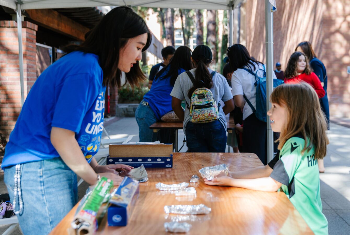 A UCLA student volunteer interacts with a young K12 student at one of the many science booths during the annual exploring your universe event on campus