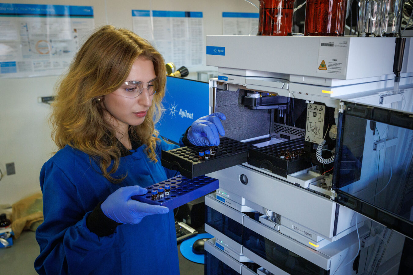 A student in the chemistry lab working with an Agilent LC/MS system