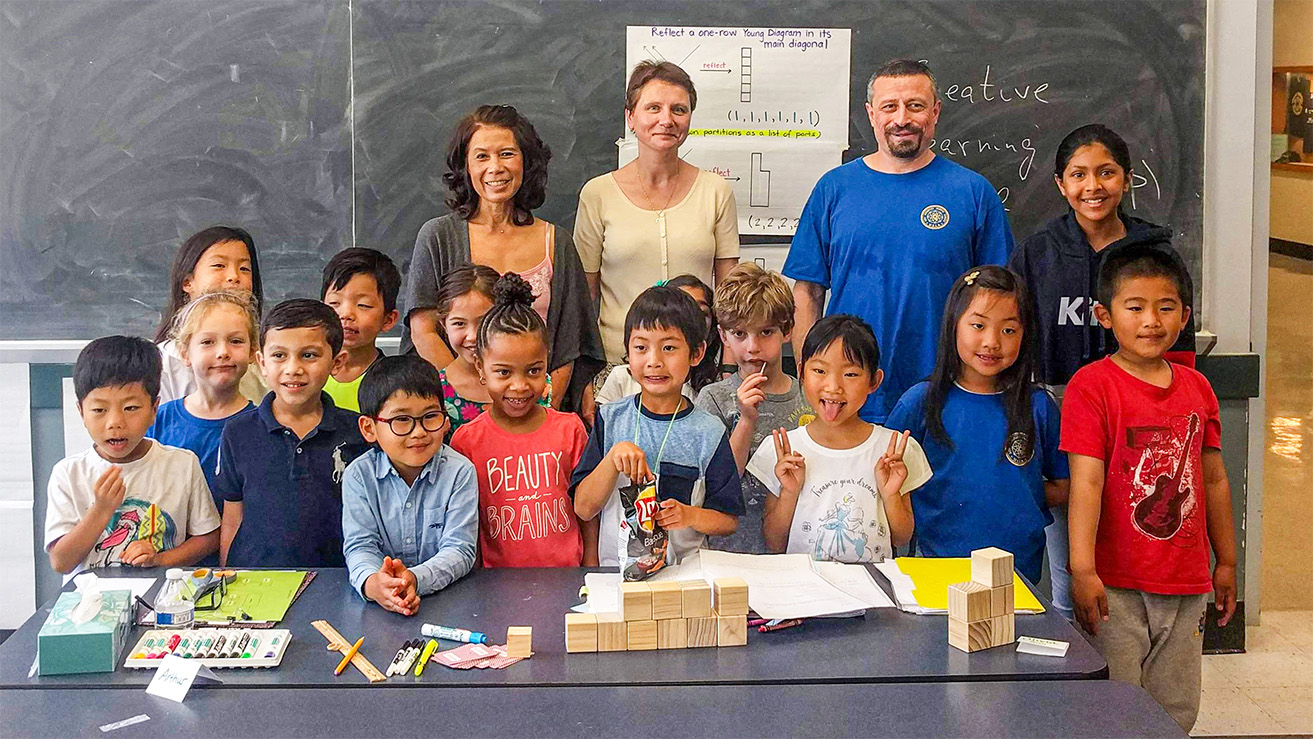 Math circle leaders post in the classroom with elementary school children