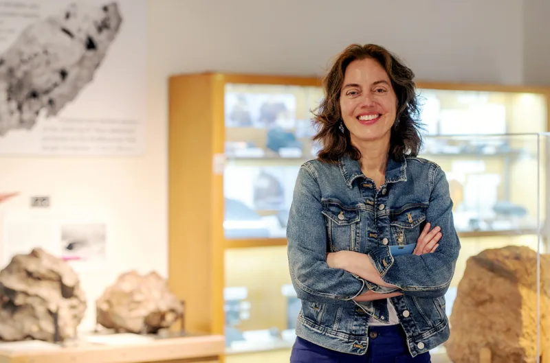 Amy Mainzer poses for a picture in her lab at UCLA surrounded by asteroids